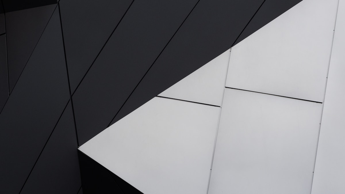 Architectural still life showing sleek geometric aluminum layouts contrasted against a glowing screen.